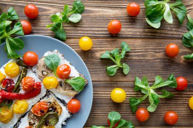 Kahverengi kırsal masa arka planında ızgara sebzeli sandviç ve sebze.. 