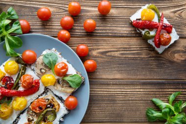 Izgara domatesli, krem peynirli ve kahverengi masada yeşil sandviçler. Metin için boşluk. 