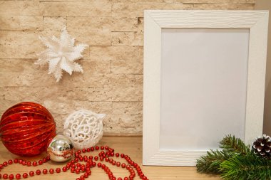 Gümüş ve beyaz noel süslemesi. Kırmızı cam ve beyaz parıldayan noel topları, kırmızı bekoratif boncuklar ve köknar ağacı dalı. Model yap. Boşluğu ve boş alanı kopyala. Tuğla duvar arkaplanı. 