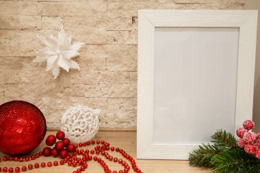 Noel modeli. Beyaz kar taneli beyaz çerçeve, kırmızı noel topu, karla kaplı kırmızı böğürtlen, köknar ağacı dalları ve tuğla duvar zemininde kırmızı boncuklar. Boşluğu kopyala. 