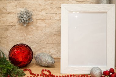 Gümüş ve kırmızı noel baloları süsleme, noel çerçevesi, gümüş kar tanesi, kırmızı boncuklar ve tuğla duvar arkasında köknar ağacı dalı olan kırmızı kış meyveleri. Uzayı kopyala Model.