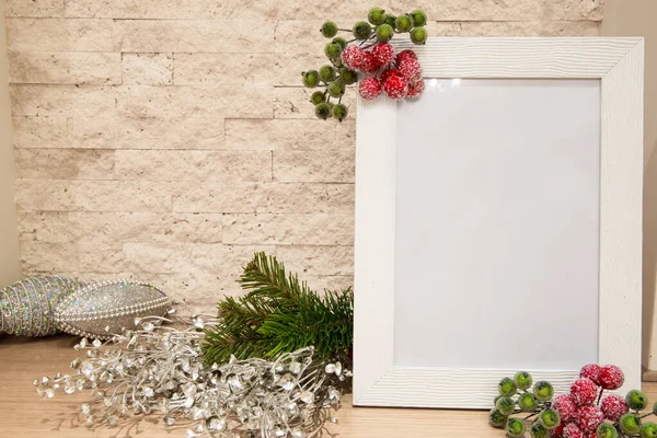 Noel modeli, köknar dalları, gümüş Noel süsü ve kırmızı ve yeşil dut çerçeveli ışıltılı Noel topu, tuğla duvar arka planı. 