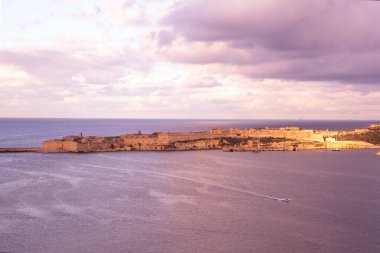 Valletta 'da pembe gün batımı, Akdeniz ve eski kale duvarları, hava manzarası. 