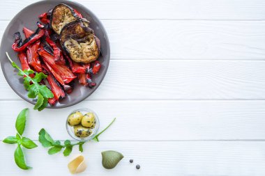 Beyaz ahşap masada gri tabakta ızgara kırmızı biber ve yumurta tabağı. Boşluğu kopyala, metin için boşluk. 