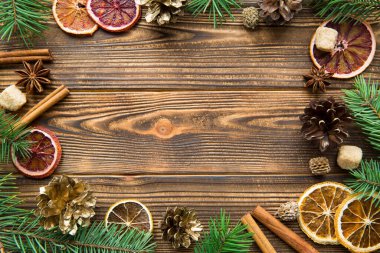 Noel bayramı kahverengi arka planı. Kurutulmuş Sicilya portakalları tarçın çubukları, anason ve altın koniler. Boşluğu kopyala. 