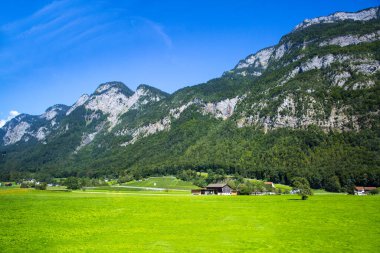 Dolomitler Apls, İsviçre panoraması. Dolomitler Alpler manzarası, yüksek dağları ve mavi gökyüzü olan yeşil vadi..