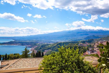 Güzel İtalyan manzarası, Etna volkanı, Akdeniz ve tipik binaların çatıları. Parlak yaz günü, Taormina, Sisli ada, İtalya. 