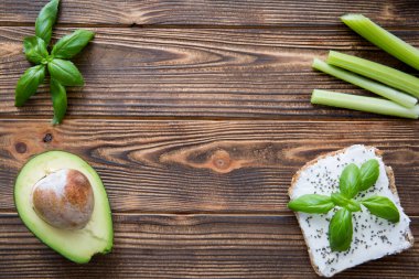 Sağlıklı sandviçler, avokado, kinoa ve kereviz çubukları kahverengi tahta masa arkasında sebze. Üst Manzara. Mesaj için yer var. Boşluğu kopyala. 