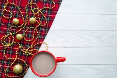 Beyaz ahşap masa arkasında bir fincan sıcak kakao. Altın Noel süslemeleri. Mesaj için yer var. Boşluğu kopyala. 
