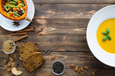 Sonbahar balkabağı baharatı. Fesleğen yapraklı balkabağı çorbası, sebzeli fırında kabak, havuç, fasulye, kayısı ve mısır. Balkabağı baharatlı kek dilimleri. Üst görünüm, alanı kopyala. 