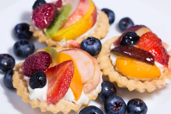Fruit tart with custard cream and fresh blueberry, strawberry, raspberry, peach and kiwi.