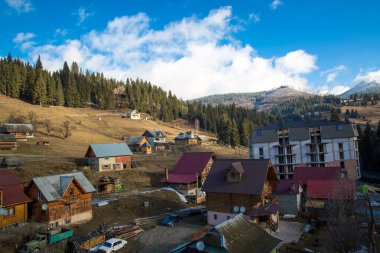 Bukovel, Carpathian dağları, Ukrayna 'da evleri, kulübeleri ve ormanları olan kış kayak merkezi manzarası. 