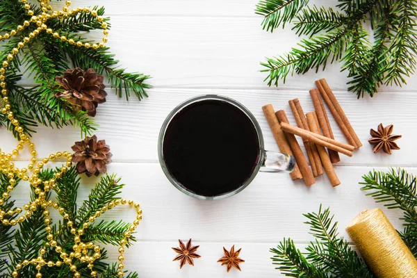 Baharatlı sıcak aromalı şarap, beyaz masada altın noel süsü, üst manzara. Aromatik kış içeceği. 