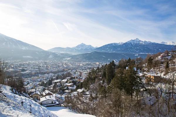 Panoramic view of Innsbruck, Austria. Houses covered with snow and Alps mountains at the background.