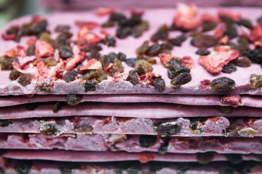 Kurutulmuş meyveli pembe çikolata: çilek ve kuru üzüm parçaları. El yapımı tatlılar.. 