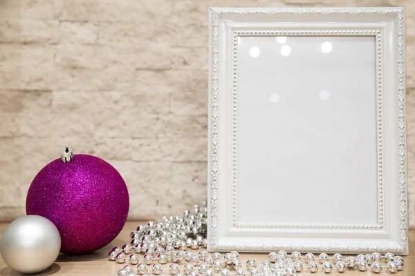 Mock up christmas decoration. New Year greeting frame with glass beads and violet purple and silver christmas balls (toys). Cope space. Brick wall background.