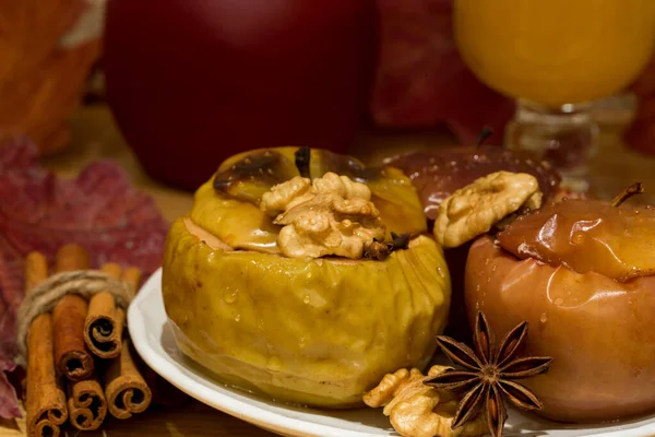 Baked apples with honey, cooked with red wine and brown sugar. Decorated with cnnamon, walnuts and anise stars. Close up.