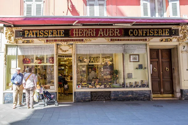 Güzel, Fransa - 18 Nisan 2017. Nice, France Riviera, Fransa 'daki pastanenin vitrininde. Eski binanın güzel yüzü. Dükkanın önüne bakan turistler. 