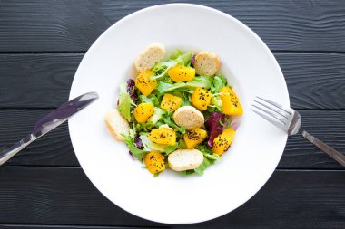 Kabaklı taze salata, kızarmış ekmek, yeşiller ve kırsal arka planda sumac baharatları.. 