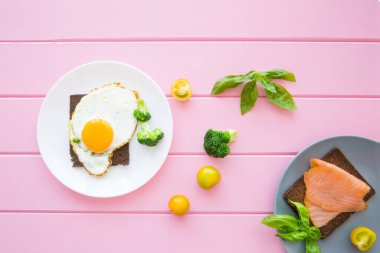 Tütsülenmiş somon tostlu nefis yumurtalar sebzeli ve ahşap arka planda yeşiller, üst manzara.. 