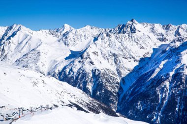 Solden, Tirol, Avusturya 'da kayak merkezi. Güzel kayalık dağlar, vadideki köy ve teleferikler. Güneşli kış günü. 