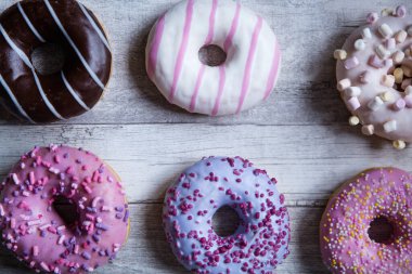 Gri ahşap masa arkaplanındaki donut çeşitleri. 