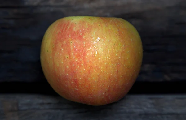 Ahşap arka plan üzerinde ıslak elma  