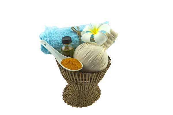 Wellness-Kräuterkompressionsball, weiße Frangipani-Blüten, Kurkuma-Pulver in weißem Massageöl und blauer Faris auf Bambuskorb isolieren auf weißem Hintergrund. Stockbild