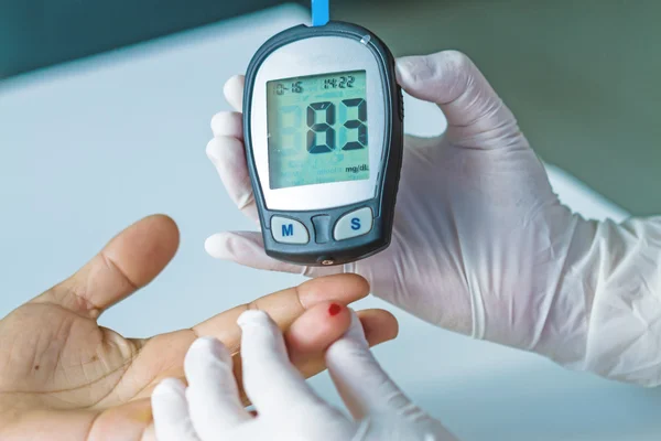 Glucómetro de sangre, el valor de azúcar en sangre se mide en un dedo — Foto de Stock