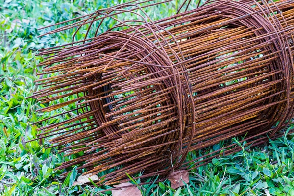 Varilla de acero vieja para la construcción en hierba verde — Foto de Stock