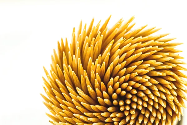 Cerrar palillos de dientes de bambú marrón sobre fondo blanco en la vista superior Imagen De Stock
