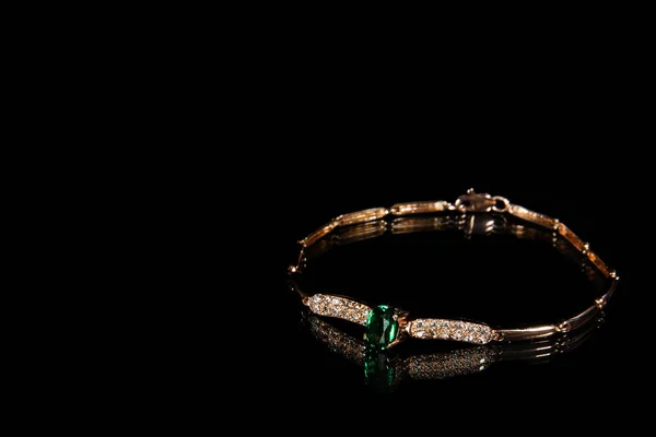 Χρυσό βραχιόλι με πολύτιμοι λίθοι και σμαράγδια και διαμάντια σε μαύρο φόντο σε στούντιο — Φωτογραφία Αρχείου