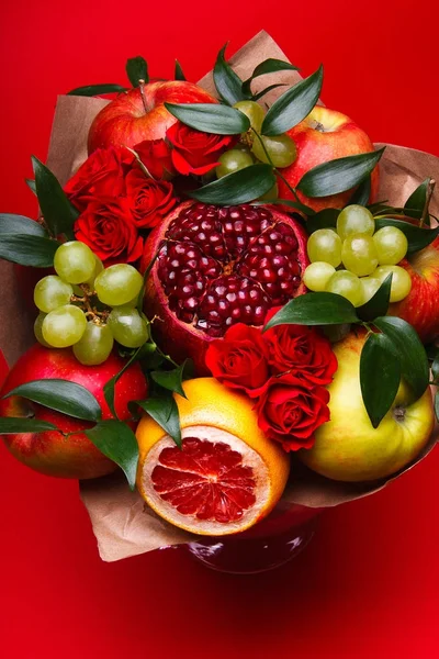 Photo of a bouquet made with fruits on a red background in studio