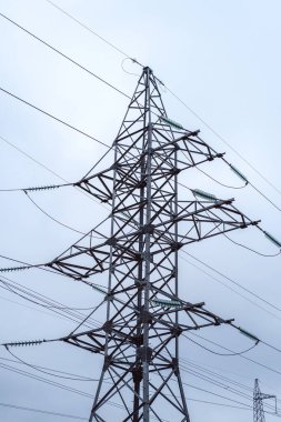 Bulutlu gökyüzüne karşı yüksek voltajlı elektrik direği