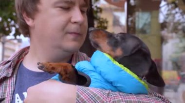 Adam köpeğini kollarına alır, gülümser ve gider. Köpek sahibini seve seve yalıyor..