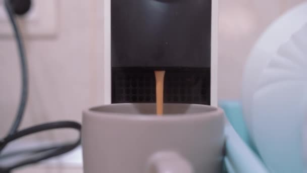 Fluxo de café quente está derramando em uma xícara de uma máquina de café cápsula compacta — Vídeo de Stock