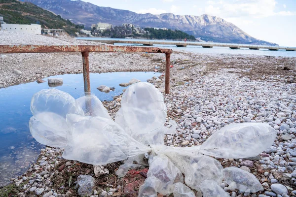 The buck of deflated balloons on the deserted pebbles beach.