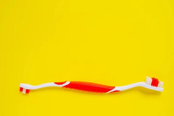 Toothbrush for pets on a yellow background.