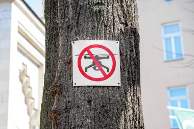 Bu bölgede insansız hava araçlarının kullanılamayacağına dair yasak işareti şehirdeki ağaçta asılı. Rahat yaşam için modern teknoloji. Özel mülke ait sınırların ihlali. Havada uçmak için izin.