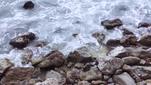 Vågor bryter på stranden med stora stenar. — Stockvideo