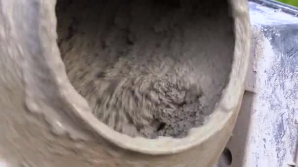 Processo de mistura de pasta de cimento com areia e cascalho em um misturador de concreto no canteiro de obras, de perto. Tecnologia de fabricação de materiais de ligação utilizados na construção e engenharia civil . — Vídeo de Stock