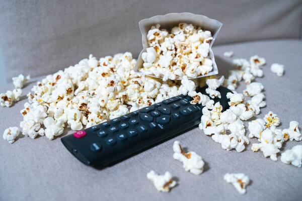 Телевизор с пультом дистанционного управления и картонная коробка с мозолями, разбрасывающимися повсюду
.