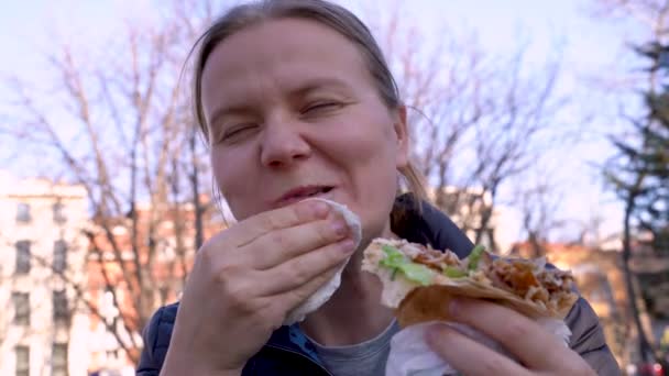 Joven mujer caucásica hambrienta comer comida rápida . — Vídeos de Stock