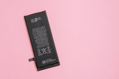11 Nisan 2020, Rostov-on-Don, Rusya: pembe arka planda Apple iPhone 6 'dan lityum iyon siyah pil. Akıllı telefonundaki eski hasarlı pili değiştiriyorsun.