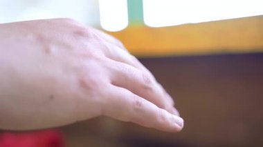 Elleri silahına uzanmış, tahta masaya uzanmış..