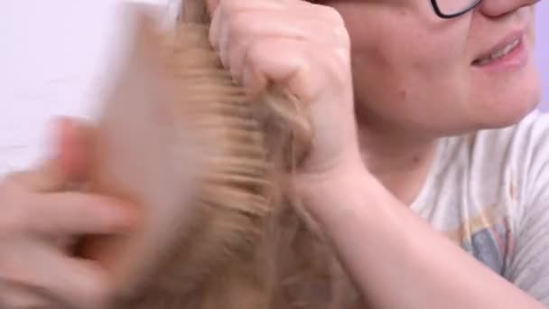 Femme peigne les cheveux très mats avec une brosse à cheveux incandescente de la douleur et de l'inconfort — Video