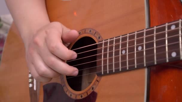 Homem tocando guitarra acústica em casa. Cordas de dedos e acordes com os dedos — Vídeo de Stock