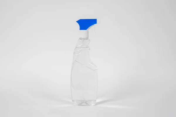 Garrafa de plástico com atomizador azul e líquido transparente ou gel dentro de pé sobre fundo branco . — Fotografia de Stock