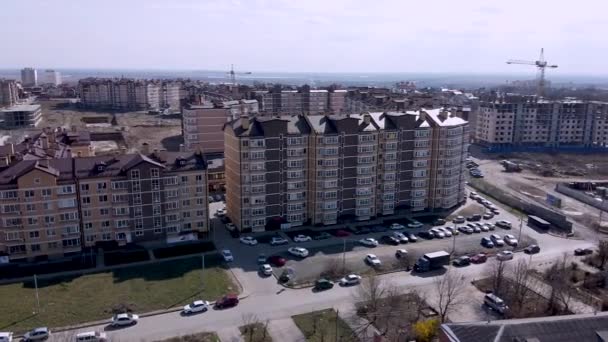Rundumaufnahme von Häusern und Wohngebieten mit Hochhäusern aus der Luft mit Drohne aus der Luft. Stadtlandschaft des Stadtteils mit Rasenflächen und Straßen an einem sonnigen Tag. — Stockvideo