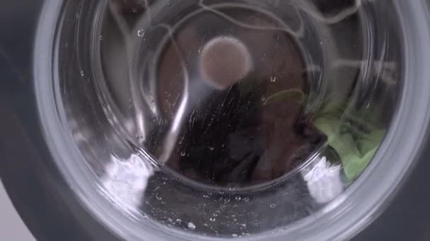 Mosás ruhák a mosógép a munkafolyamat során. színes vászon mosoda — Stock videók